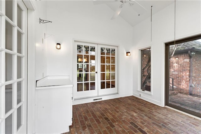 14908 E Pawhuska Rd, Nevada, MO 64772 - unfurnished sunroom with french doors, brick floors, and high vaulted ceiling