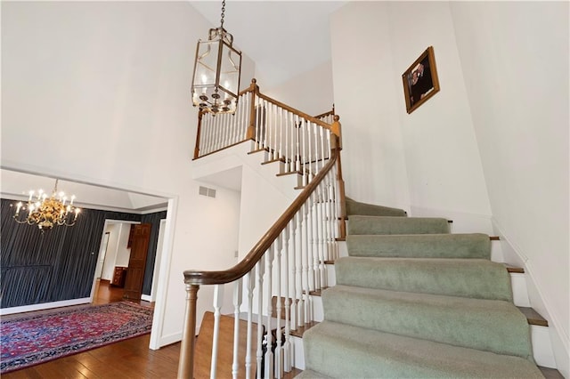 14908 E Pawhuska Rd, Nevada, MO 64772 - stairway with a chandelier, hardwood / wood-style floors, and a towering ceiling