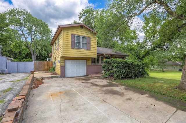 8519 Woodland Ave, Kansas City, MO 64131 - tri-level home with concrete driveway, an attached garage, and brick siding