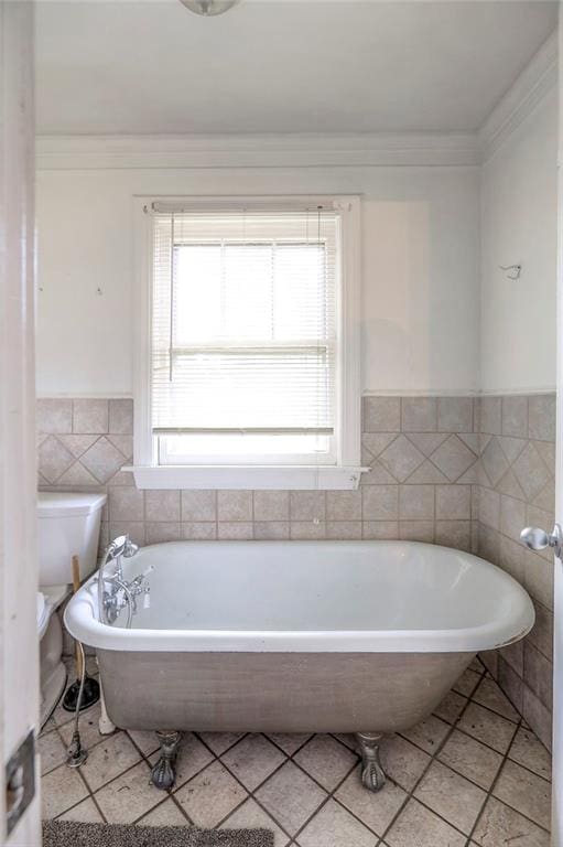 8519 Woodland Ave, Kansas City, MO 64131 - full bathroom with healthy amount of natural light, a soaking tub, tile walls, ornamental molding, and a wainscoted wall