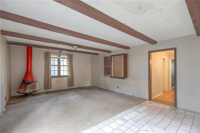 8519 Woodland Ave, Kansas City, MO 64131 - spare room featuring beam ceiling and a wood stove