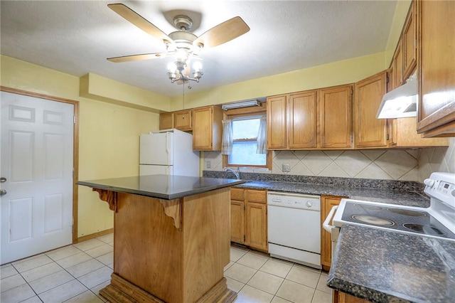 8519 Woodland Ave, Kansas City, MO 64131 - kitchen featuring white appliances, under cabinet range hood, a ceiling fan, dark countertops, and light tile patterned floors