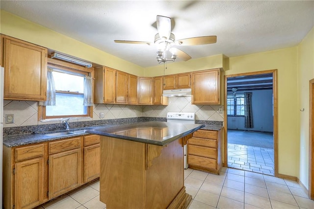 8519 Woodland Ave, Kansas City, MO 64131 - kitchen featuring under cabinet range hood, dark countertops, tasteful backsplash, white electric range oven, and a textured ceiling