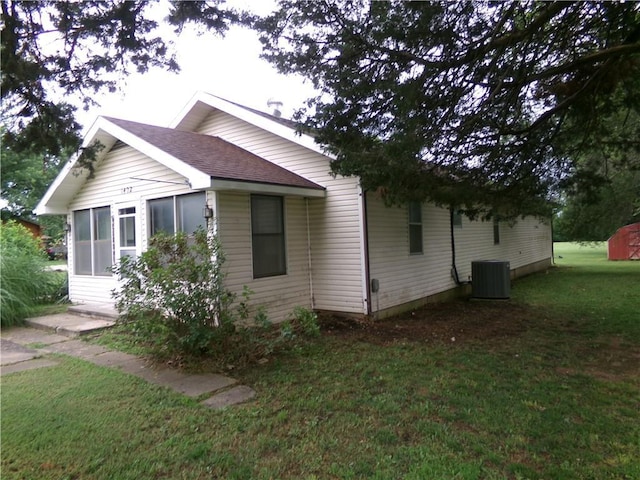 1402 N Kentucky St, Iola, KS 66749 - view of property exterior featuring a lawn, a sunroom, and roof with shingles