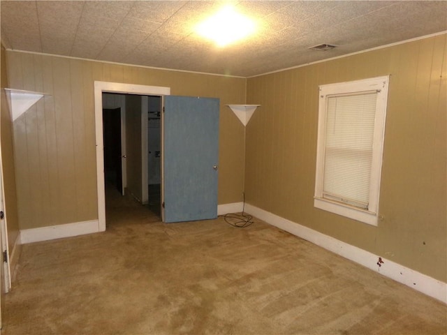 1402 N Kentucky St, Iola, KS 66749 - empty room featuring carpet, wood walls, and crown molding