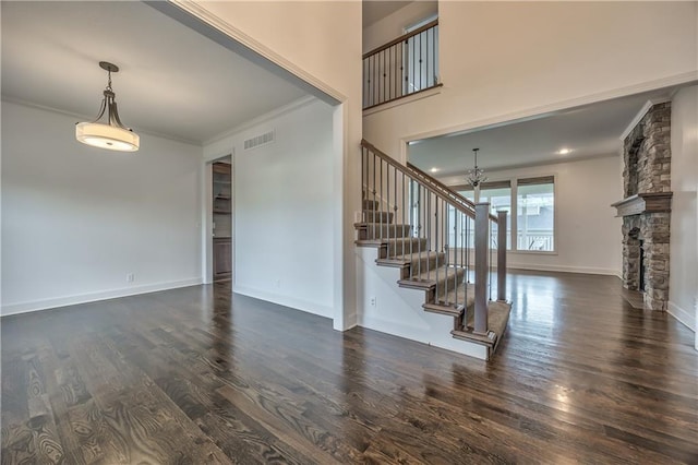 14017 Haskins St, Overland Park, KS 66221 - foyer entrance with stairway, crown molding, dark wood-type flooring, a chandelier, and a stone fireplace