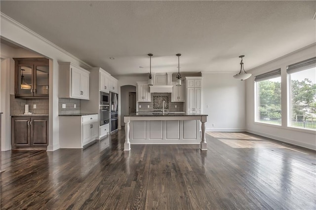 14017 Haskins St, Overland Park, KS 66221 - kitchen featuring dark countertops, stainless steel appliances, decorative backsplash, dark wood-type flooring, and a kitchen bar