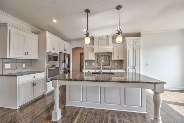 14017 Haskins St, Overland Park, KS 66221 - kitchen with appliances with stainless steel finishes, arched walkways, backsplash, crown molding, and a breakfast bar
