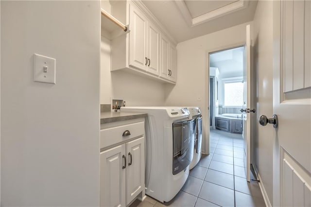 14017 Haskins St, Overland Park, KS 66221 - laundry area with cabinet space, washer and clothes dryer, and light tile patterned floors