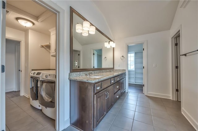 14017 Haskins St, Overland Park, KS 66221 - bathroom featuring independent washer and dryer, tile patterned flooring, lofted ceiling, and double vanity