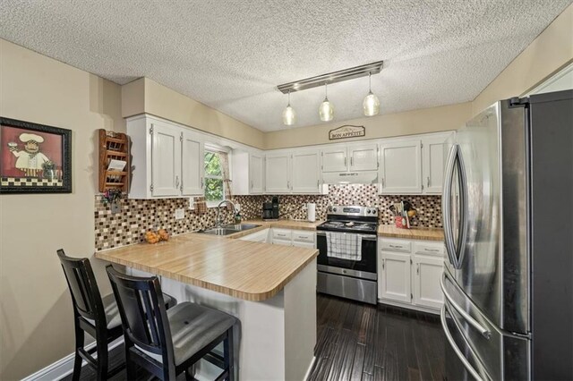 16304 W 126th St, Olathe, KS 66062 - kitchen featuring appliances with stainless steel finishes, a peninsula, under cabinet range hood, light countertops, and white cabinetry