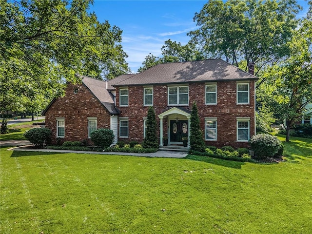 11401 Cedar St, Leawood, KS 66211 - colonial home with a front yard, brick siding, a chimney, and roof with shingles