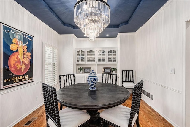 11401 Cedar St, Leawood, KS 66211 - dining room with a tray ceiling, a chandelier, and wood finished floors