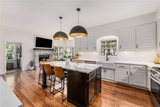 11401 Cedar St, Leawood, KS 66211 - kitchen with a breakfast bar, a kitchen island, appliances with stainless steel finishes, backsplash, and a fireplace