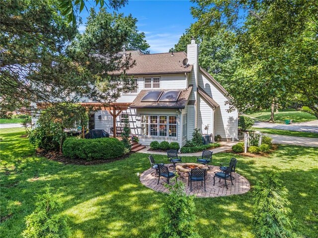11401 Cedar St, Leawood, KS 66211 - back of house with an outdoor fire pit, a lawn, and a chimney