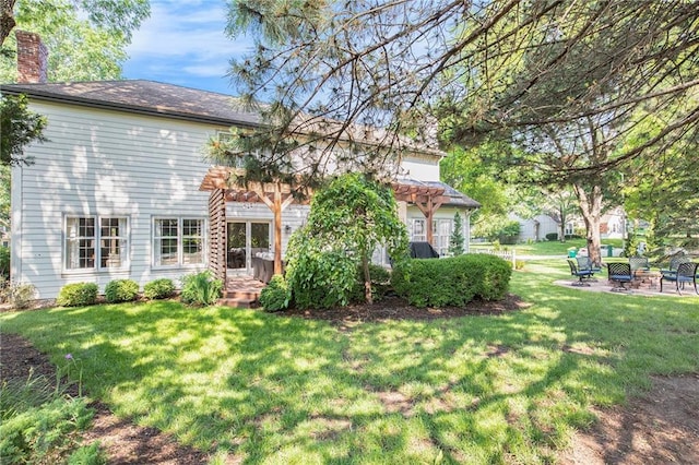 11401 Cedar St, Leawood, KS 66211 - back of house with a lawn, a chimney, a patio area, and an outdoor fire pit