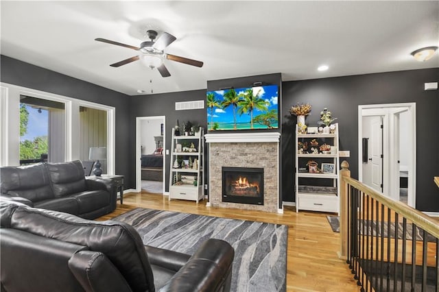 1013 SE Beatty Ct, Blue Springs, MO 64014 - living room featuring a ceiling fan, wood finished floors, a stone fireplace, and recessed lighting