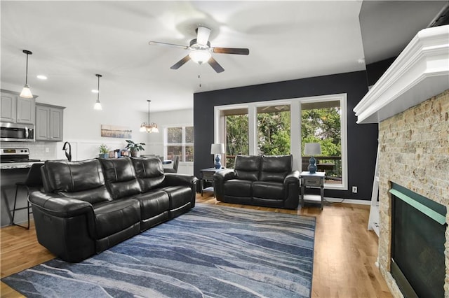 1013 SE Beatty Ct, Blue Springs, MO 64014 - living area featuring ceiling fan, healthy amount of natural light, a stone fireplace, wood finished floors, and recessed lighting