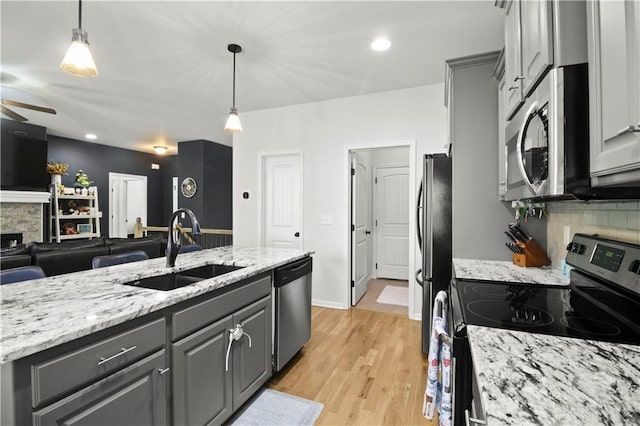 1013 SE Beatty Ct, Blue Springs, MO 64014 - kitchen featuring stainless steel appliances, gray cabinetry, ceiling fan, open floor plan, and decorative backsplash