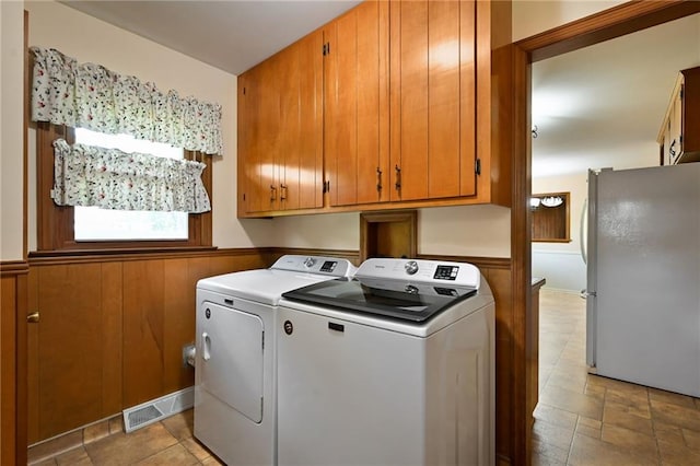 4411 W 89th St, Prairie Village, KS 66207 - washroom featuring washer and clothes dryer, cabinet space, wainscoting, and light stone finish flooring