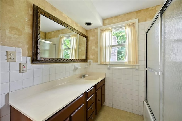 4411 W 89th St, Prairie Village, KS 66207 - full bath with tile walls, vanity, healthy amount of natural light, enclosed tub / shower combo, and a baseboard heating unit