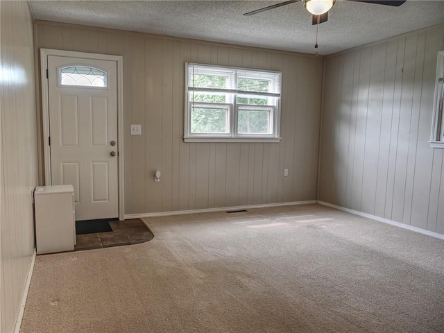 715 N Warren St, Warrensburg, MO 64093 - entrance foyer featuring a ceiling fan, carpet flooring, plenty of natural light, a textured ceiling, and wood walls