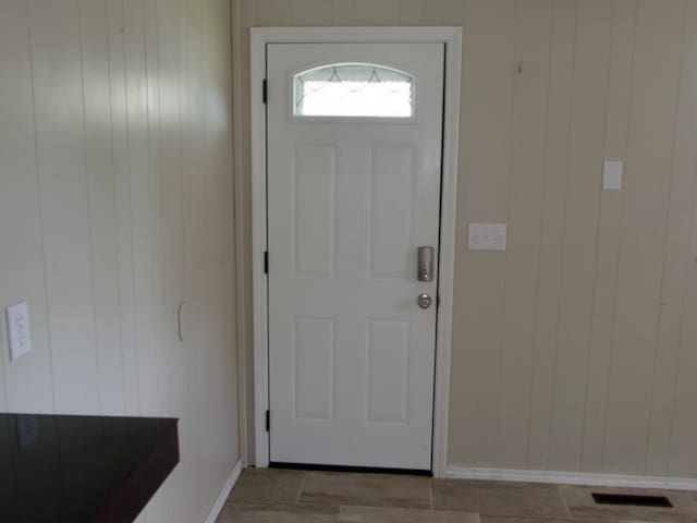 715 N Warren St, Warrensburg, MO 64093 - doorway to outside with baseboards and wood walls