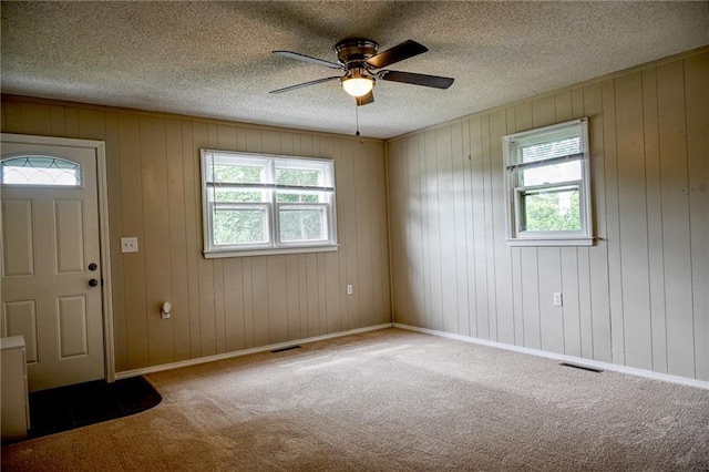 715 N Warren St, Warrensburg, MO 64093 - carpeted entryway with ceiling fan, a textured ceiling, and wooden walls