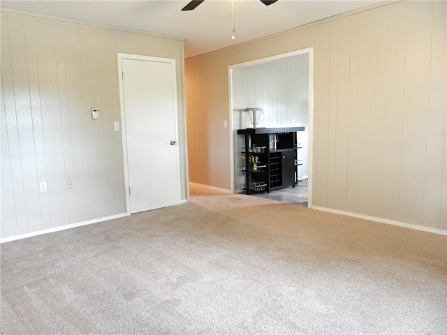 715 N Warren St, Warrensburg, MO 64093 - carpeted empty room featuring a ceiling fan and wood walls