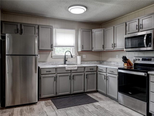 715 N Warren St, Warrensburg, MO 64093 - kitchen featuring stainless steel appliances, gray cabinets, light countertops, and a textured ceiling