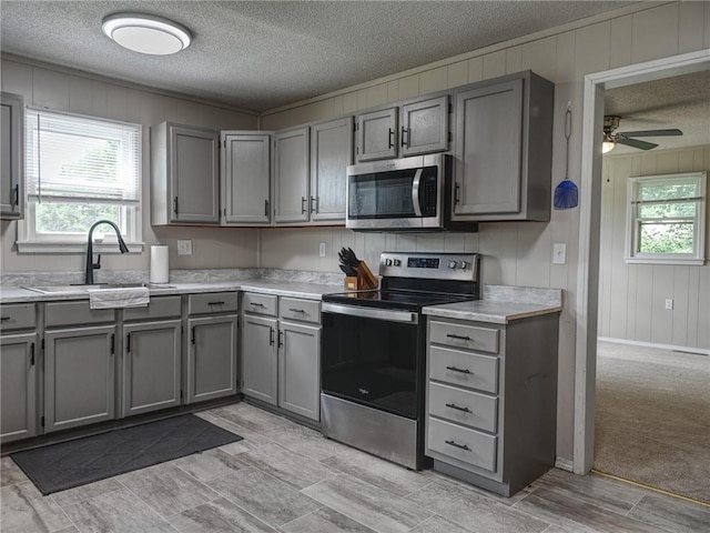 715 N Warren St, Warrensburg, MO 64093 - kitchen with stainless steel appliances, gray cabinets, a textured ceiling, light countertops, and ceiling fan
