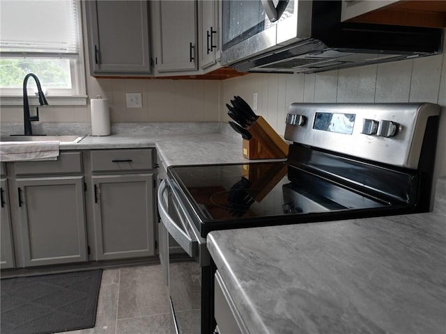 715 N Warren St, Warrensburg, MO 64093 - kitchen with stainless steel electric range oven, gray cabinetry, light countertops, and tile patterned flooring