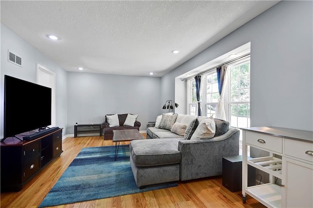 809 E 110th St, Kansas City, MO 64131 - living area featuring light wood finished floors, a textured ceiling, and recessed lighting