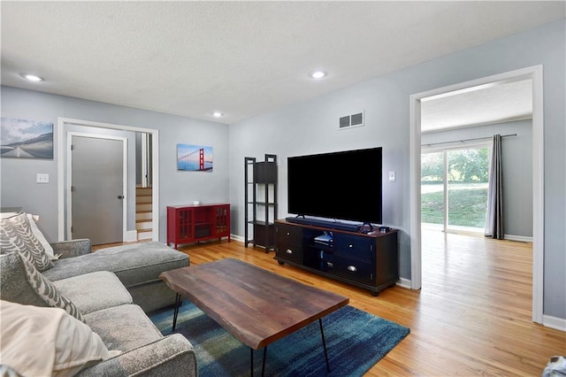 809 E 110th St, Kansas City, MO 64131 - living area featuring light wood finished floors, stairway, recessed lighting, and a textured ceiling