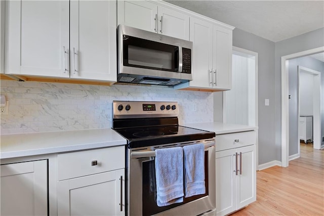 809 E 110th St, Kansas City, MO 64131 - kitchen with stainless steel appliances, light countertops, white cabinets, and light wood-style floors