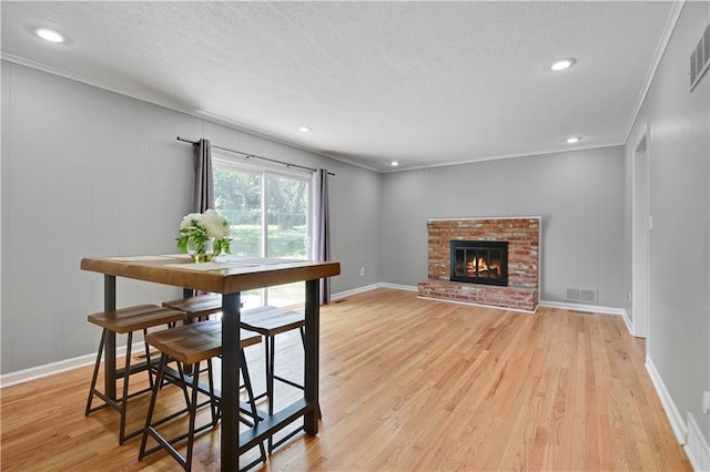 809 E 110th St, Kansas City, MO 64131 - dining area featuring light wood finished floors, a textured ceiling, ornamental molding, recessed lighting, and a fireplace