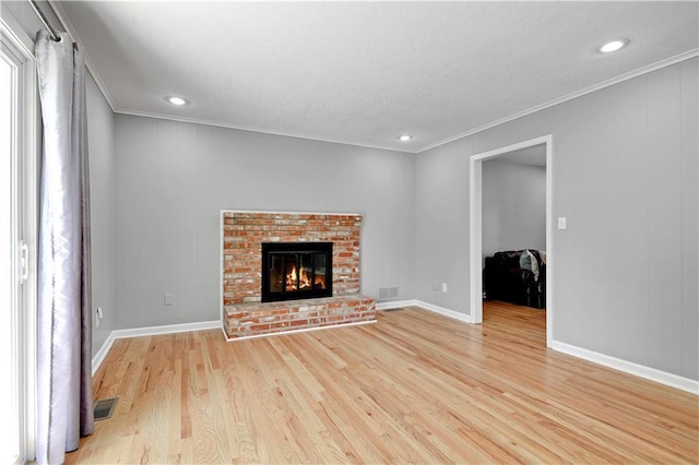 809 E 110th St, Kansas City, MO 64131 - unfurnished living room with crown molding, light wood finished floors, a brick fireplace, and recessed lighting