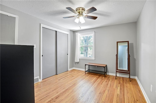 809 E 110th St, Kansas City, MO 64131 - unfurnished bedroom with light wood finished floors, a textured ceiling, a closet, and a ceiling fan