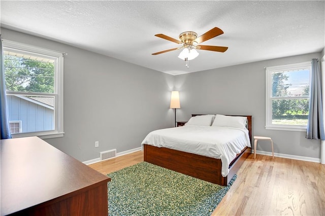809 E 110th St, Kansas City, MO 64131 - bedroom featuring light wood-type flooring, ceiling fan, and a textured ceiling