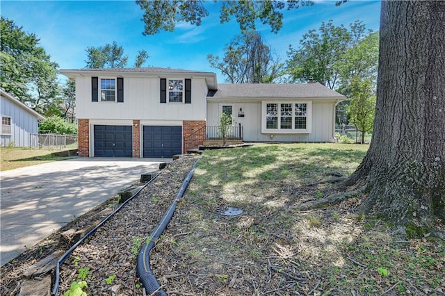 809 E 110th St, Kansas City, MO 64131 - split level home featuring concrete driveway, brick siding, and a garage