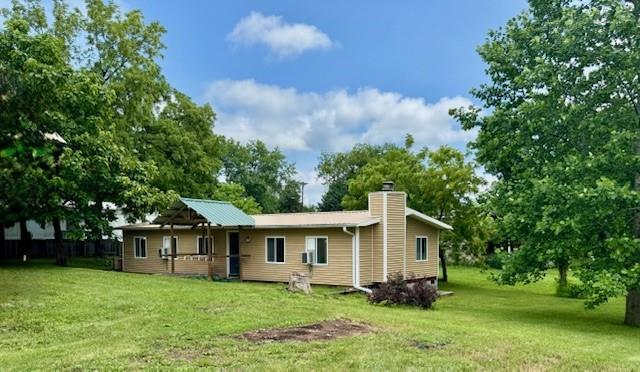 2745 169th Hwy, Trimble, MO 64492 - rear view of property featuring a chimney and a lawn