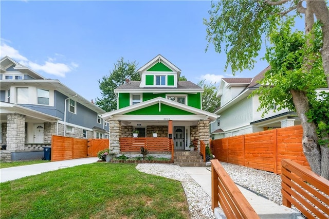 3230 Bellefontaine Ave, Kansas City, MO 64128 - american foursquare style home featuring stone siding, covered porch, and a gate