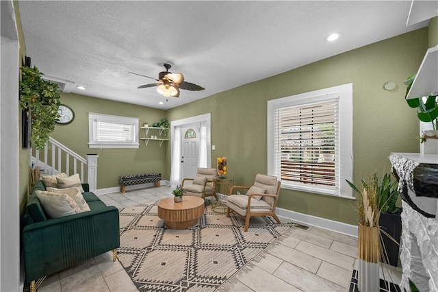 3230 Bellefontaine Ave, Kansas City, MO 64128 - living room with ceiling fan, light tile patterned floors, stairs, and recessed lighting