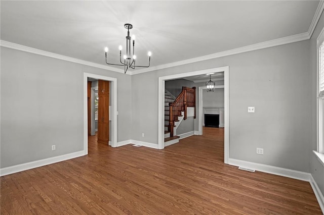 1535 W 75th St, Kansas City, MO 64114 - unfurnished room featuring a chandelier, stairway, crown molding, and wood finished floors