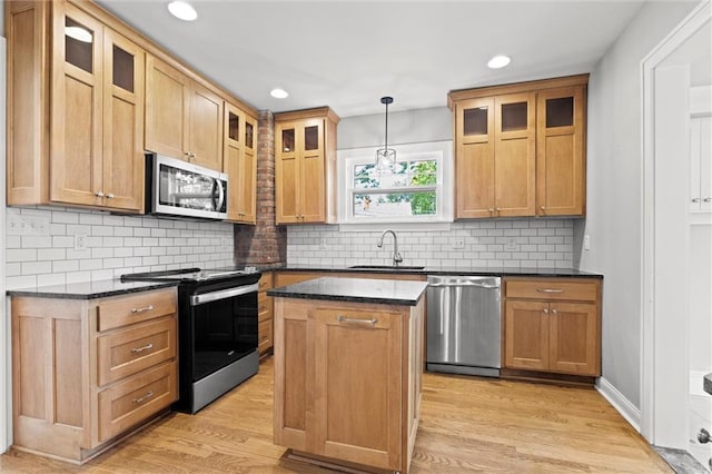 1535 W 75th St, Kansas City, MO 64114 - kitchen with stainless steel appliances, recessed lighting, a kitchen island, light wood-style floors, and tasteful backsplash