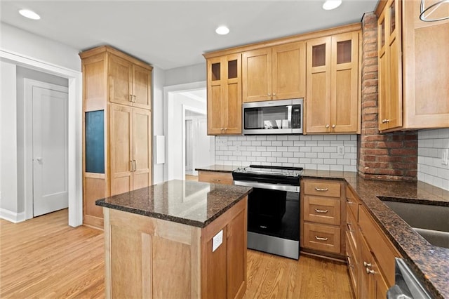 1535 W 75th St, Kansas City, MO 64114 - kitchen with appliances with stainless steel finishes, light wood-style floors, a kitchen island, recessed lighting, and glass insert cabinets