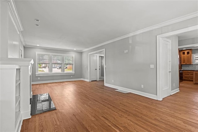 1535 W 75th St, Kansas City, MO 64114 - unfurnished living room with wood finished floors, crown molding, and recessed lighting