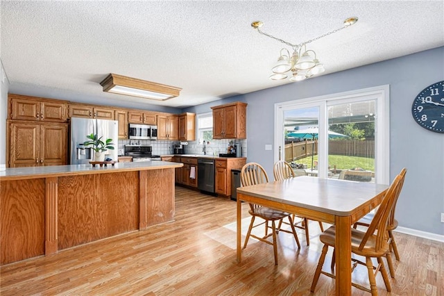 2417 SW Woodhaven Ln, Lees Summit, MO 64082 - dining area featuring a textured ceiling, light wood finished floors, and a chandelier