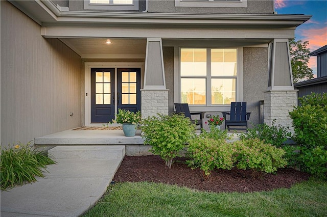 20487 W 108th St, Olathe, KS 66061 - exterior entry at dusk featuring a porch and stucco siding