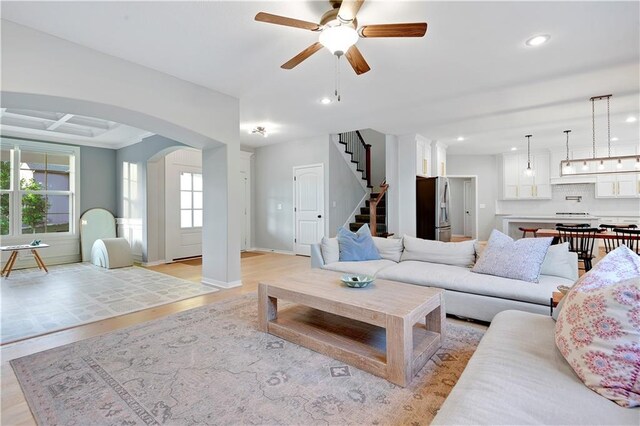 20487 W 108th St, Olathe, KS 66061 - living area with ceiling fan, recessed lighting, arched walkways, stairs, and light wood-style flooring